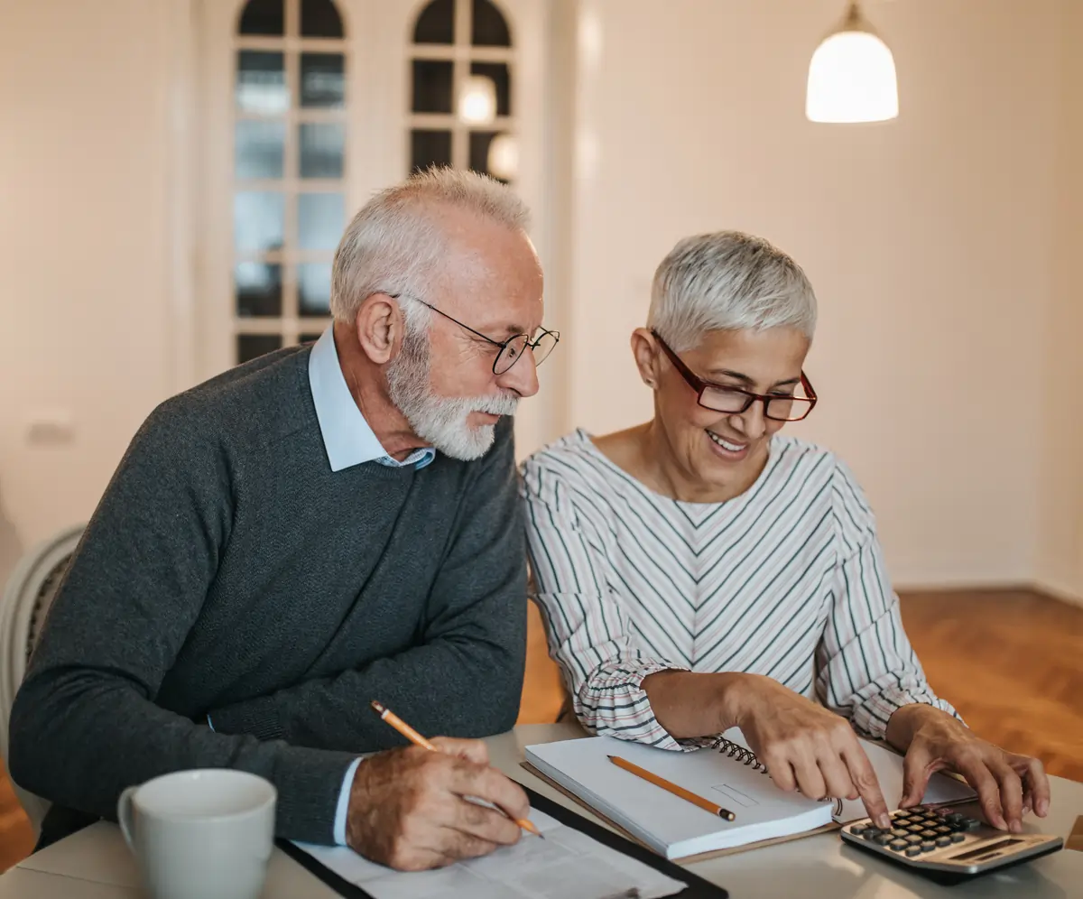 Elderly couple calculating their expenses.