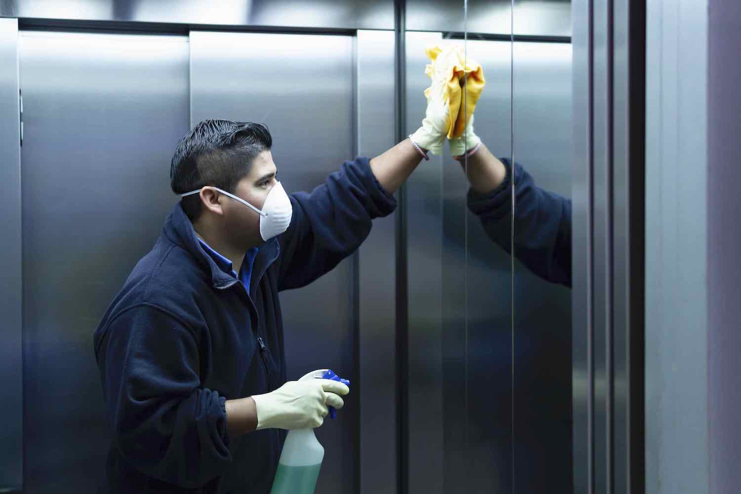 A man cleans an elevator at a senior living facility.